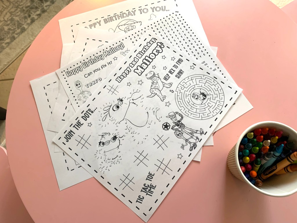 Custom Toy Story-themed birthday coloring pages with crayons on a kids’ table