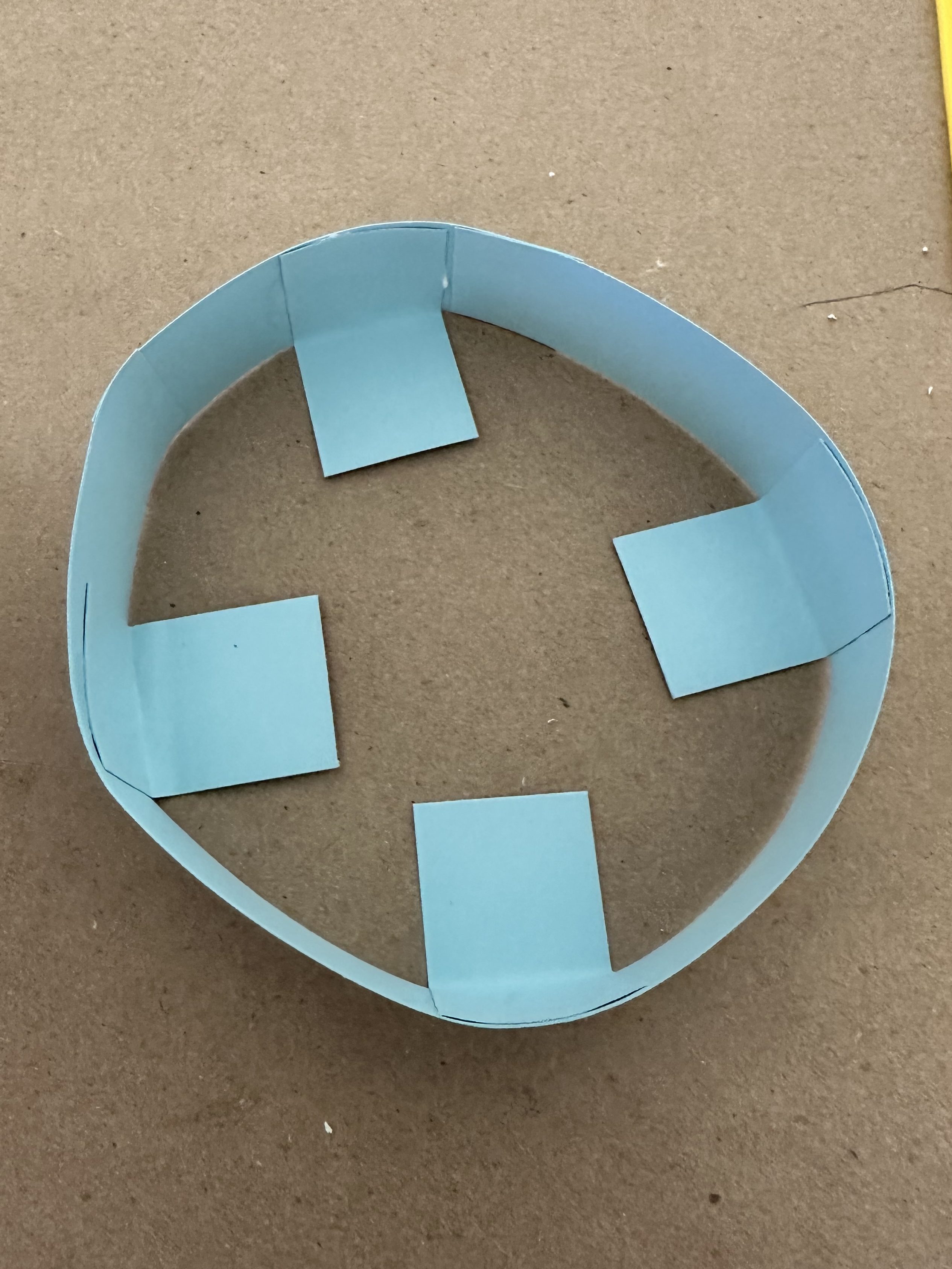 Blue cardstock ring with folded tabs glued inside to form the base of the Bob-omb’s hat.