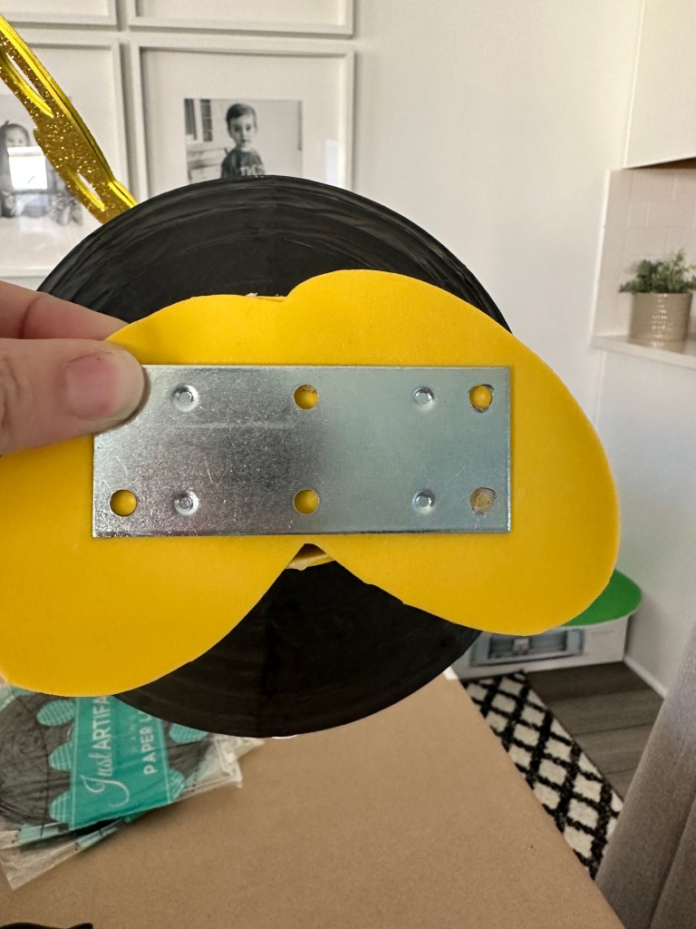 Bottom of Bob-omb showing a metal mending plate glued to the feet for weight and stability.