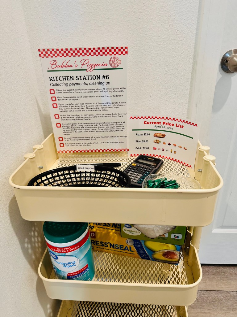 Kitchen Station #6 at Bubba’s Pizzeria, with guest check instructions, price list, calculator, chocolates, wipes, and supplies for cleaning up.