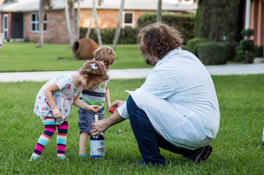 Two young party guests stand ready to trigger the Mentos and Diet Cola experiment.