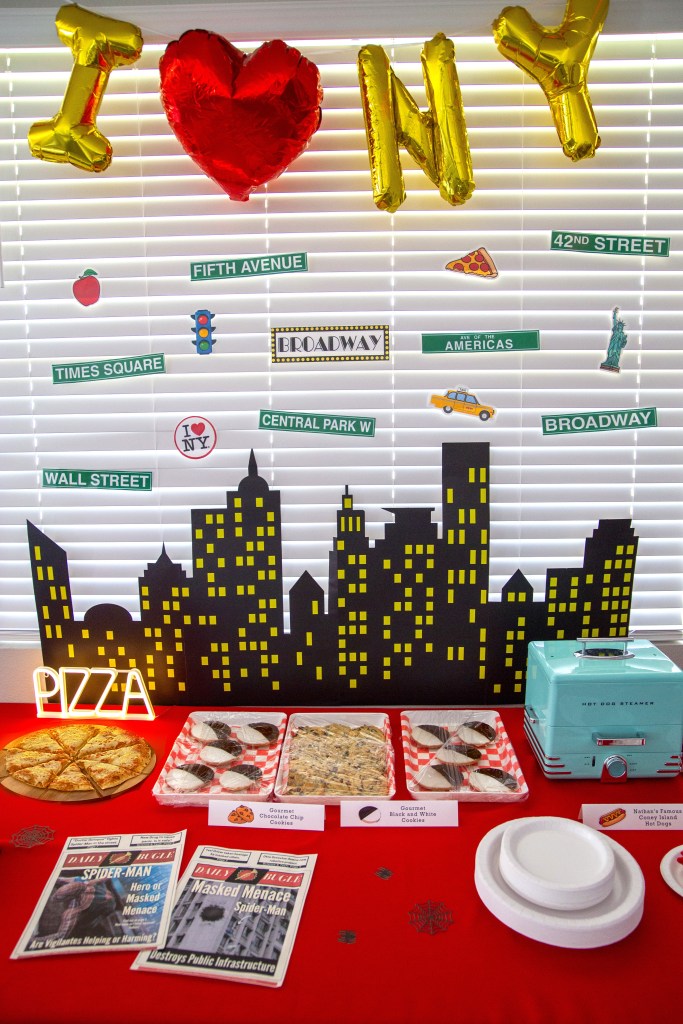 New York City themed party food table with skyline backdrop, I ❤️ NY balloons, and simple kid-friendly menu setup.