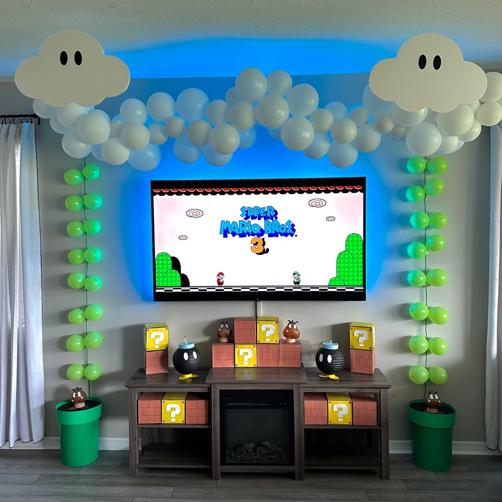 Balloon vines, foam clouds, and Mario blocks create a Sky Land backdrop for a Super Mario 3 birthday party.