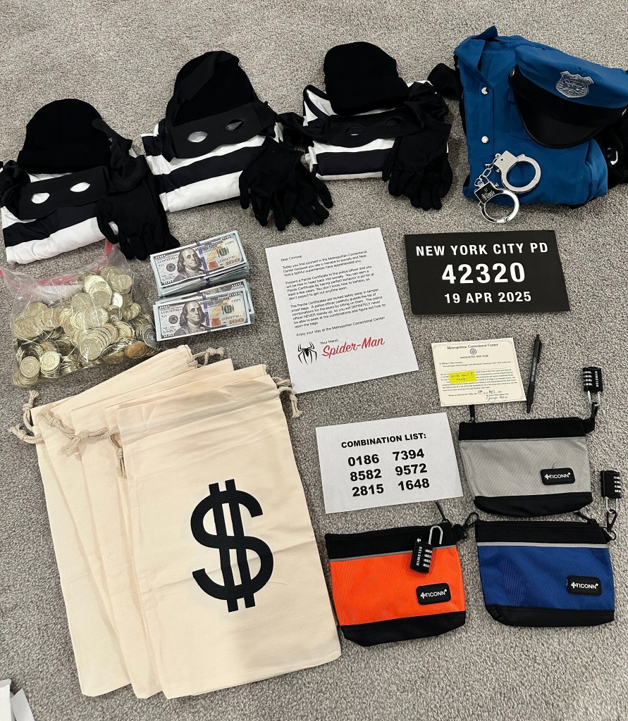 Overhead view of all the supplies for the Superheroes vs. Robbers party game, including robber costumes, police uniform, cash bags, fake money, locked pouches, combination list, and Spider-Man letter.