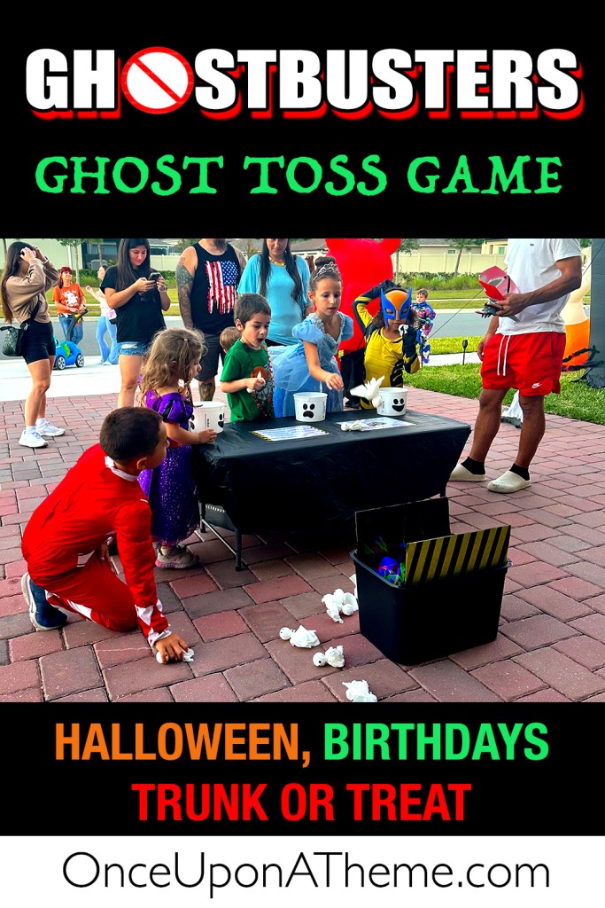 Kids in costumes playing a Ghost Toss game with ghost face buckets at a Halloween event inspired by Ghostbusters.