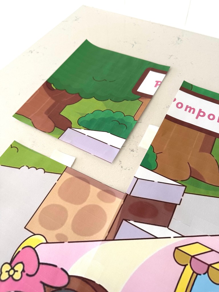 Close-up of two printed sheets being carefully aligned and taped together to create a seamless large image.